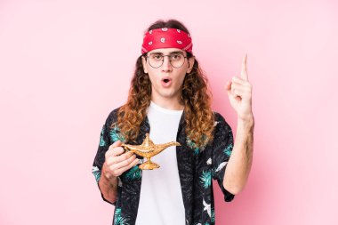 Uzun saçlı, beyaz bir adam elinde sihirli bir lamba tutuyor. Harika bir fikri var. Yaratıcılık kavramı..