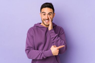 Mor arka planda izole edilmiş genç beyaz bir adam bir dedikodu söylüyor, bir şeyi haber veriyor..