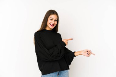 Beyaz arka planda izole edilmiş beyaz tenli genç bir kadın işaret parmağıyla işaret ederek heyecanlanıyor..