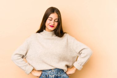 Beyazlı genç bir kadın bej arka planda izole edilmiş. Amaçlarına ve amaçlarına ulaşma hayali kuruyor.