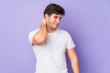 Mor arka planda izole edilmiş genç bir adam sabit yaşam tarzından dolayı boyun ağrısı çekiyor..