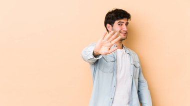 Bej arka planda izole edilmiş genç bir adam tiksinti belirtisi gösteren birini reddediyor..