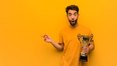 Elinde bir kupa tutan genç adam.