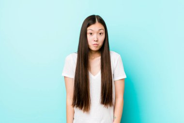 Genç, güzel Çinli kadın omuz silker ve gözleri açık kalır..