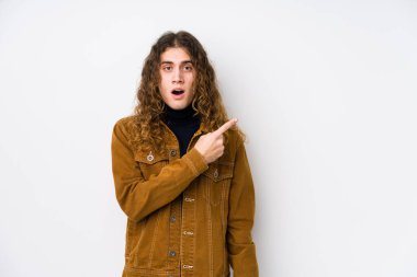 Uzun saçlı adam yanlamasına poz veriyor.