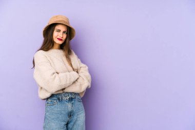 Mor arka planda izole edilmiş beyaz bir kadın mutsuz bir şekilde alaycı bir ifadeyle kameraya bakıyor..