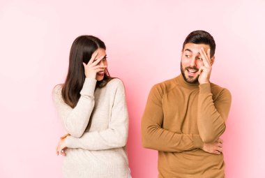 Genç beyaz çift kameraya parmaklarıyla göz kırpıyor, yüzünü kapatmaktan utanıyorlar..