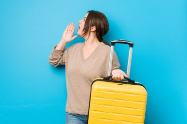 Elinde bavul tutan, bağıran ve avuç içi açık bir kadın..