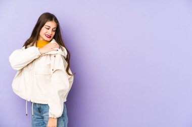 Mor arka planda izole edilmiş, omuz ağrısı olan beyaz bir kadın..