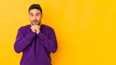 Kafkasyalı genç adam sarı fırında izole edilmiş şans için dua ediyor, şaşırmış ve ağzını açıp önüne bakıyor..