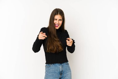 Beyaz arka planda izole edilmiş genç beyaz kadın parmaklarıyla ön tarafı işaret ediyor..