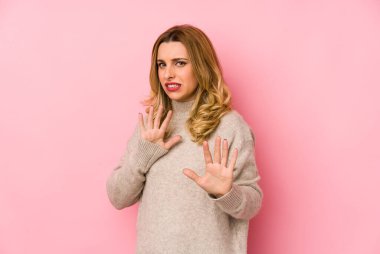 Süveter giyen genç sarışın kadın tiksinti gösteren birini reddediyor..