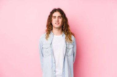 Uzun saçlı adam yalnız poz veriyor. Mutlu, güler yüzlü ve neşeli..