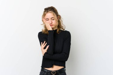 Beyaz arka plandaki genç beyaz kadın sıkılmış, yorgun ve dinlenmeye ihtiyacı var..