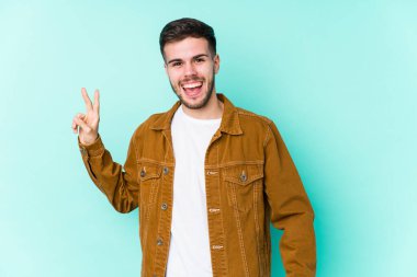 Genç yakışıklı adam neşeli ve kaygısız parmaklarıyla barış sembolü gösteriyor..