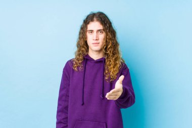 Uzun saçlı adam kameraya el sallayarak selam veriyor..