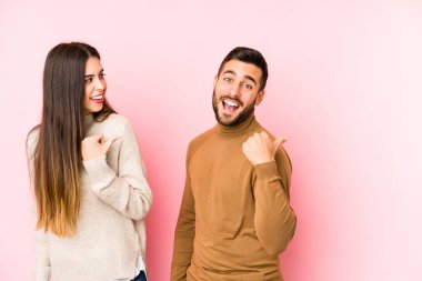 Kafkasyalı genç çift başparmak uzakta izole noktalar, gülüyor ve kaygısız.