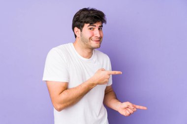 Mor arka planda izole edilmiş genç adam işaret parmağıyla fotokopi alanını göstererek şok oldu..