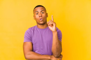 Genç latin adam sarı arka planda izole edilmiş. Harika bir fikri var. Yaratıcılık kavramı..