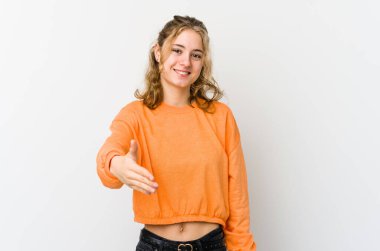 Beyaz arka planda genç beyaz bir kadın kameraya elini uzatarak selam veriyor..