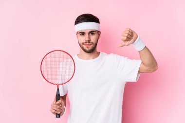 Badminton oynayan beyaz bir genç izole edilmiş, hoşlanmadığı bir jest yapıyor, kabul etmiyor. Anlaşmazlık konsepti.