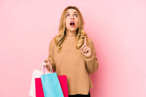 Ung Blond Kvinna Som Håller Shoppingpåsar Isolerade Pekar Upp Med — Stockfoto