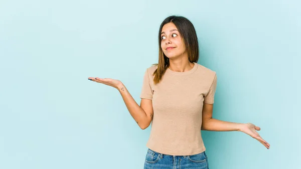 Mujer Joven Aislada Sobre Fondo Azul Confundida Dudosa Hombros Encogiéndose —  Fotos de Stock