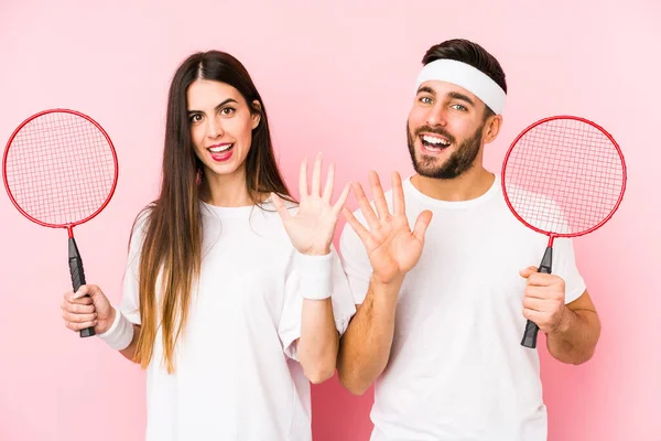 Casal Jovem Jogando Badminton Isolado Sorrindo Alegre Mostrando Número Cinco — Fotografia de Stock