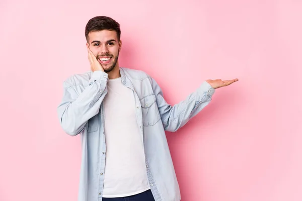 Joven Hombre Negocios Caucásico Posando Fondo Blanco Aislado Sostiene Espacio —  Fotos de Stock