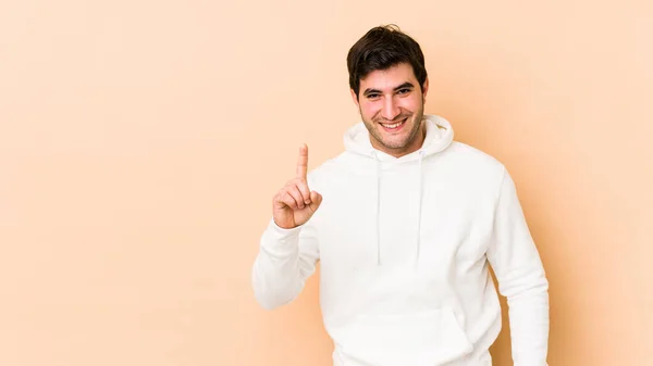 Jongeman Geïsoleerd Beige Achtergrond Tonen Nummer Een Met Vinger — Stockfoto