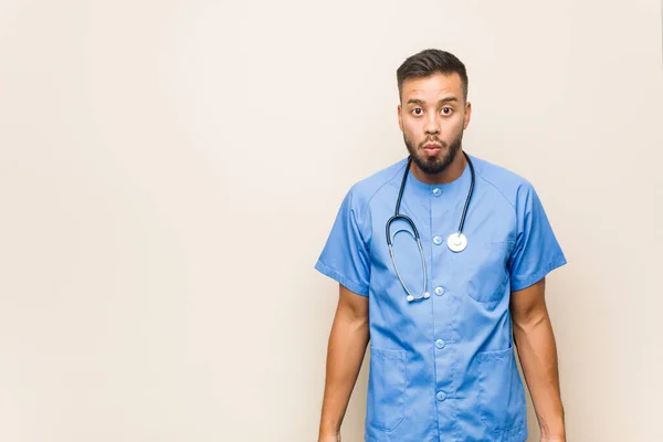 Young South Asian Nurse Man Shrugs Shoulders Open Eyes Confused — Stock Photo, Image