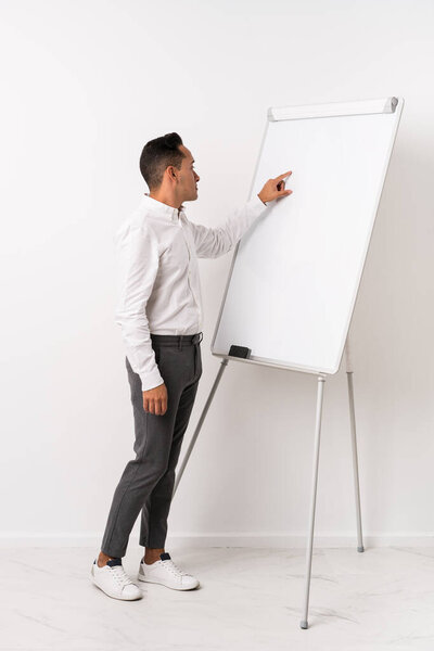 Молодой тренер латинос с белой доской