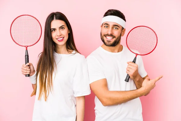 Casal Jovem Jogando Badminton Isolado Sorrindo Apontando Para Lado Mostrando — Fotografia de Stock