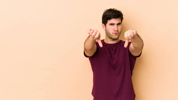 Young Man Isolated Beige Background Showing Thumb Expressing Dislike — Stock Photo, Image