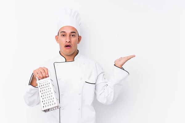 Jovem Chef Latino Homem Isolado Impressionado Segurando Espaço Cópia Palma — Fotografia de Stock