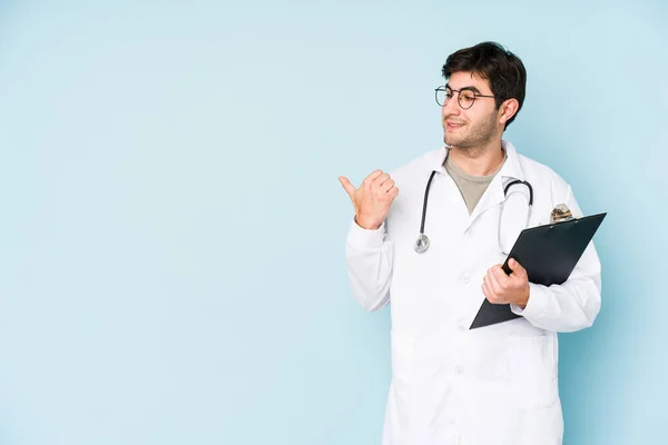 Young Doctor Man Isolated Blue Background Points Thumb Finger Away — Stock Photo, Image