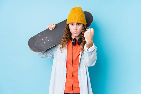 Young caucasian skater man isolated showing fist to camera, aggressive facial expression.