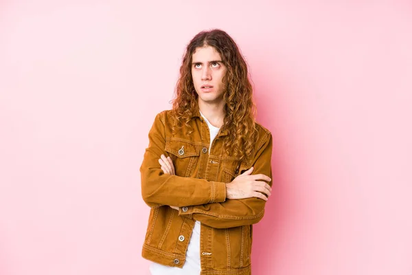 Young long hair man posing isolated tired of a repetitive task.