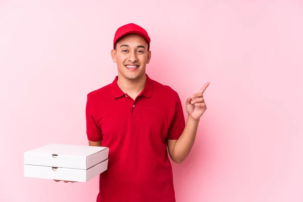 Молодой Доставка Пиццы Латинский Человек Изолирован Улыбаясь Указывая Сторону Показывая — стоковое фото