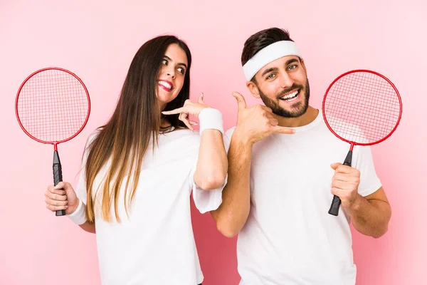 Casal Jovem Jogando Badminton Isolado Mostrando Gesto Chamada Telefone Celular — Fotografia de Stock