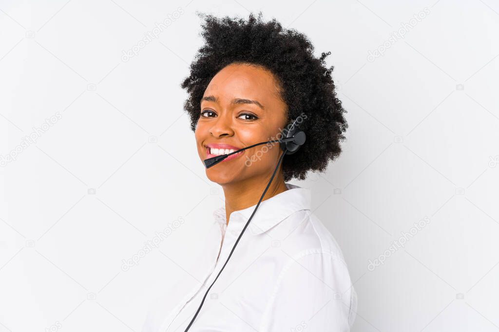 Young african american telemarketer woman isolated looks aside smiling, cheerful and pleasant.