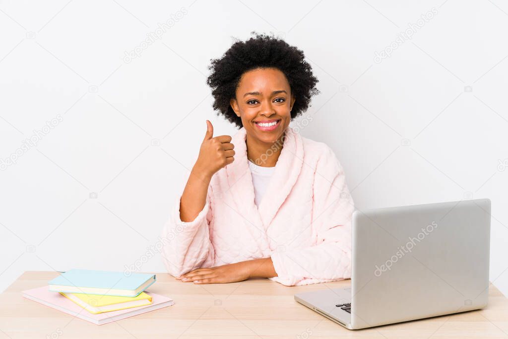 Middle aged african american woman working at home isolated smiling and raising thumb up