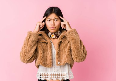 Genç Asyalı kadın bir işe odaklanmış, işaret parmaklarını işaret ediyor..