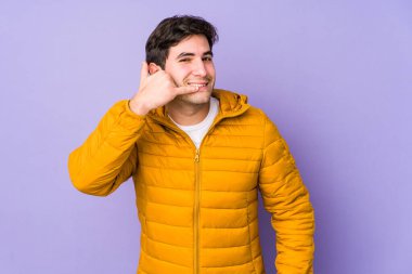 Mor arka planda izole edilmiş genç bir adam parmakları olan bir cep telefonu hareketi gösteriyor..