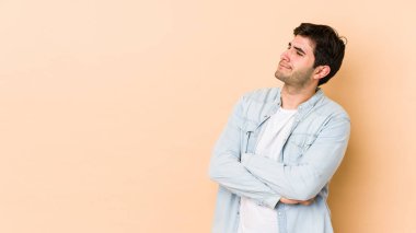 Bej arka planda izole edilmiş genç adam hedeflere ve amaçlara ulaşmayı hayal ediyor.