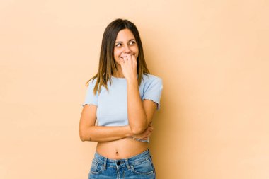 Bej arka planda izole edilmiş genç bir kadın rahatlamış fotokopi odasına bakan bir şey düşünüyor..