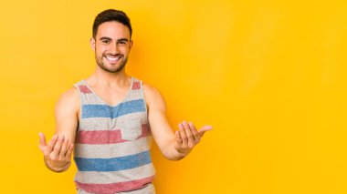 Sarı fırında izole edilmiş genç beyaz adam hoş bir yüz ifadesi sergiliyor..