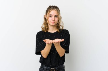 Beyaz sırtlı beyaz bir kadın elinde avuç içi bir şeyle kameraya teklif ediyor..