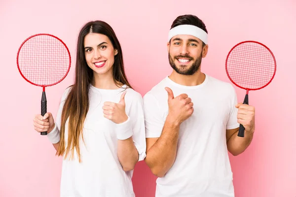 Casal Jovem Jogando Badminton Isolado Sorrindo Levantando Polegar — Fotografia de Stock