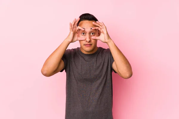 Latynoski Mężczyzna Pozowanie Różowym Tle Oczy Otwarte Aby Znaleźć Okazję — Zdjęcie stockowe